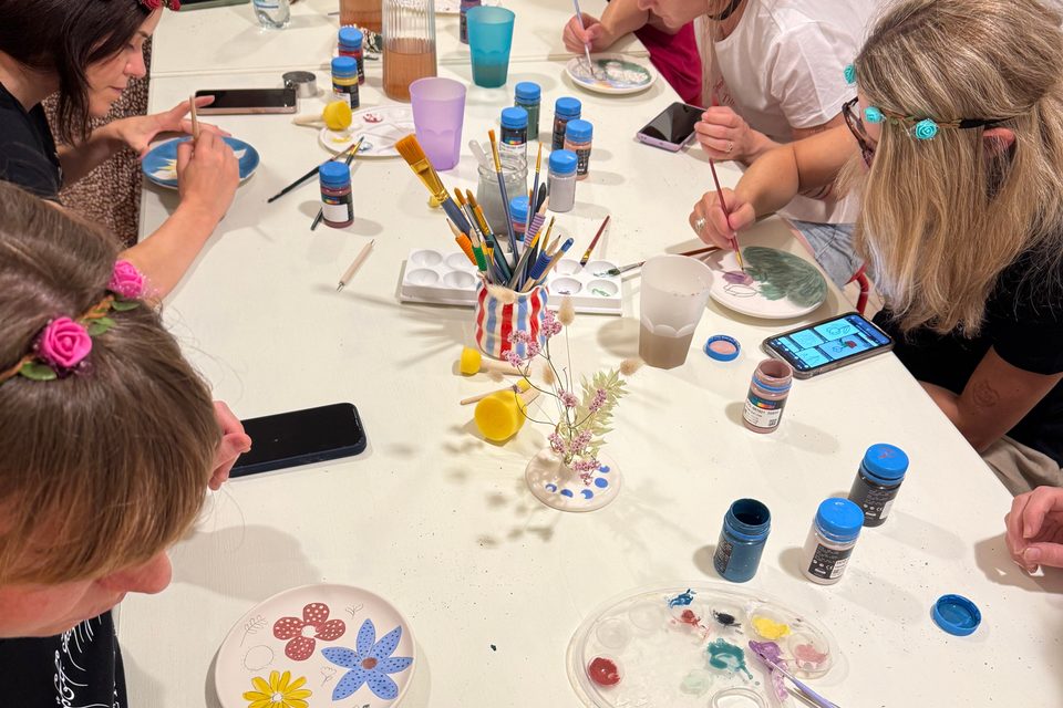 ragazze che lavorano felici su un piattino in ceramica durante un workshop privato